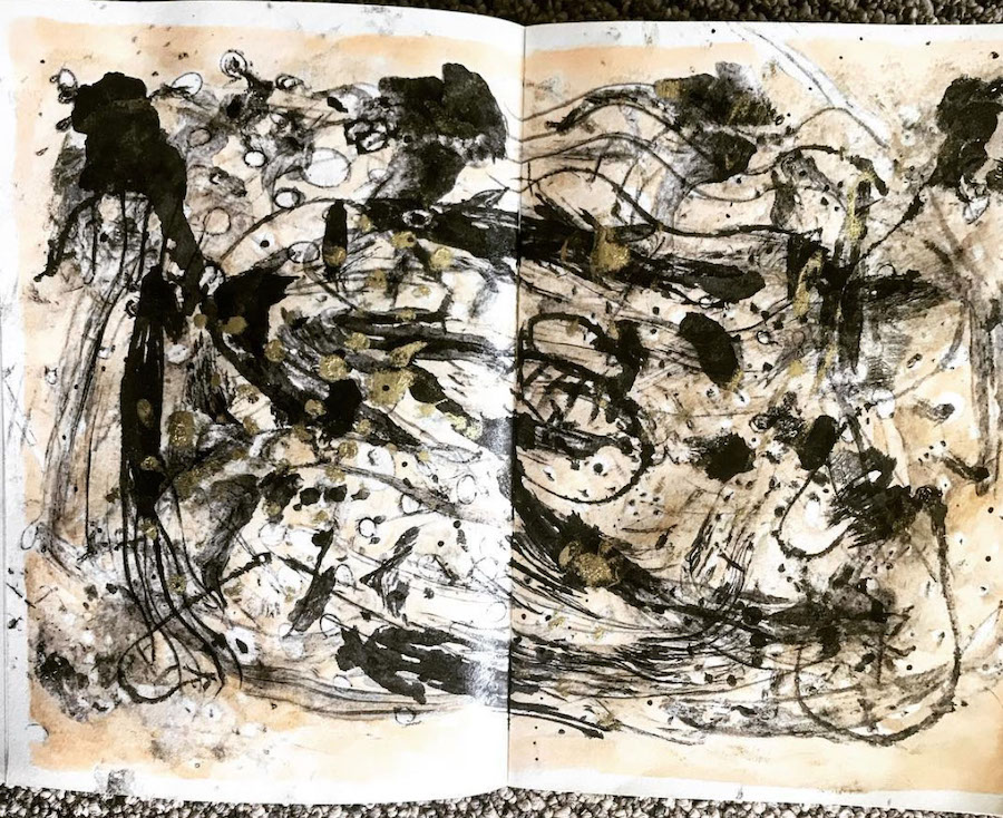 A vigorous gestural abstract painting on paper with black, gold and ochre paint.